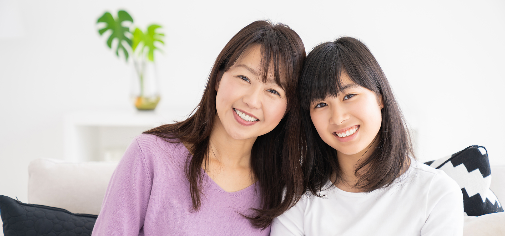 写真:笑顔で並んで座る親子